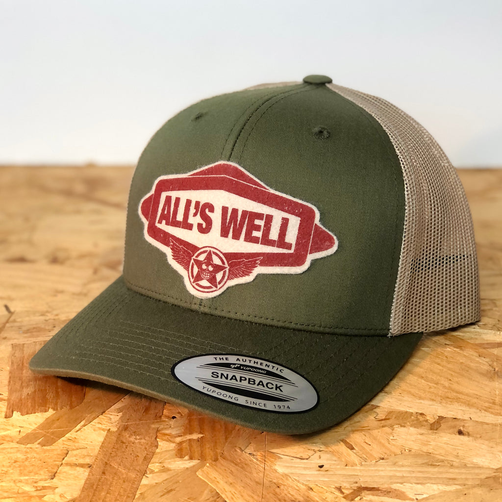 All’s Well green/khaki snapback retro trucker cap, decorated with wool felt badge designed and hand printed by us with the text all’s well