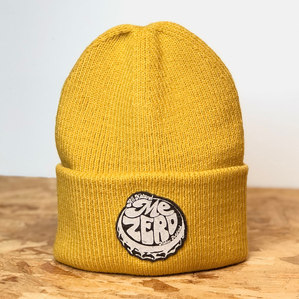 Me Zero mustard deep-cuffed 100% recycled polyester beanie, decorated with wool felt badge hand printed by All’s Well Originals with the text me zero