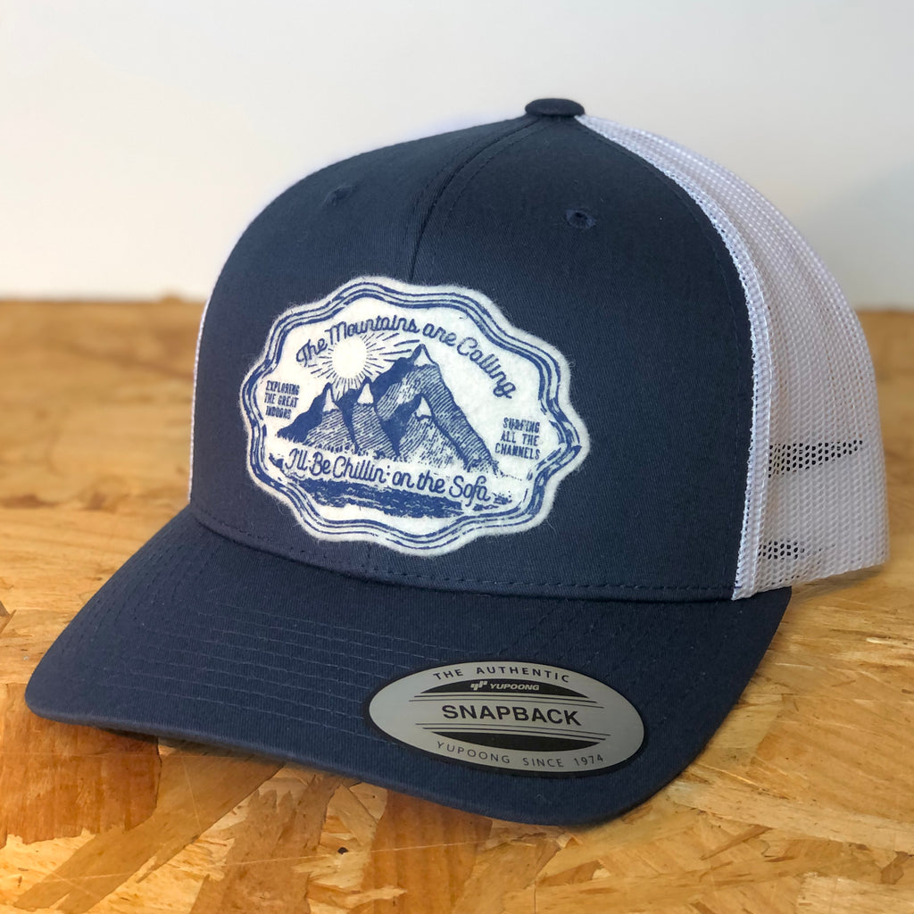 Mountains navy/white two tone snapback retro trucker cap, decorated with wool felt badge designed and hand printed by us with mountain graphic and text 